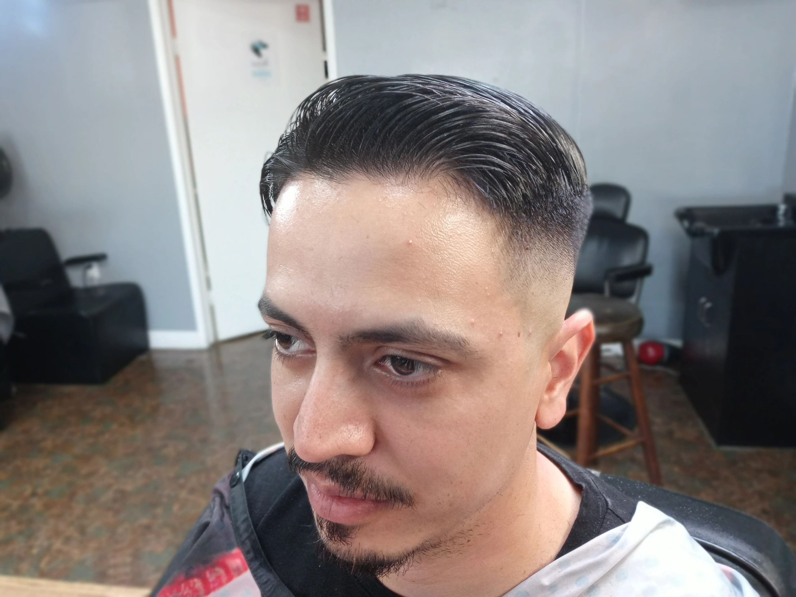 Professional barber at JW Barbershop in Lancaster CA ready to serve clients