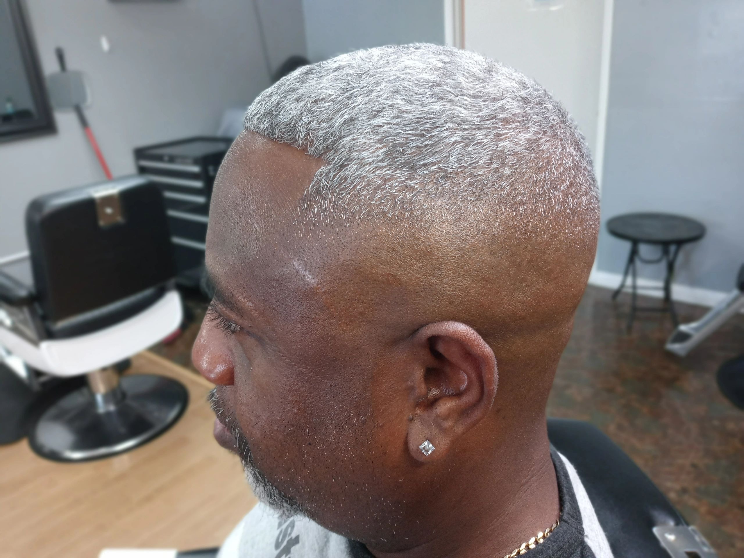 Senior gentleman with a short professional gray haircut at JW Barbershop