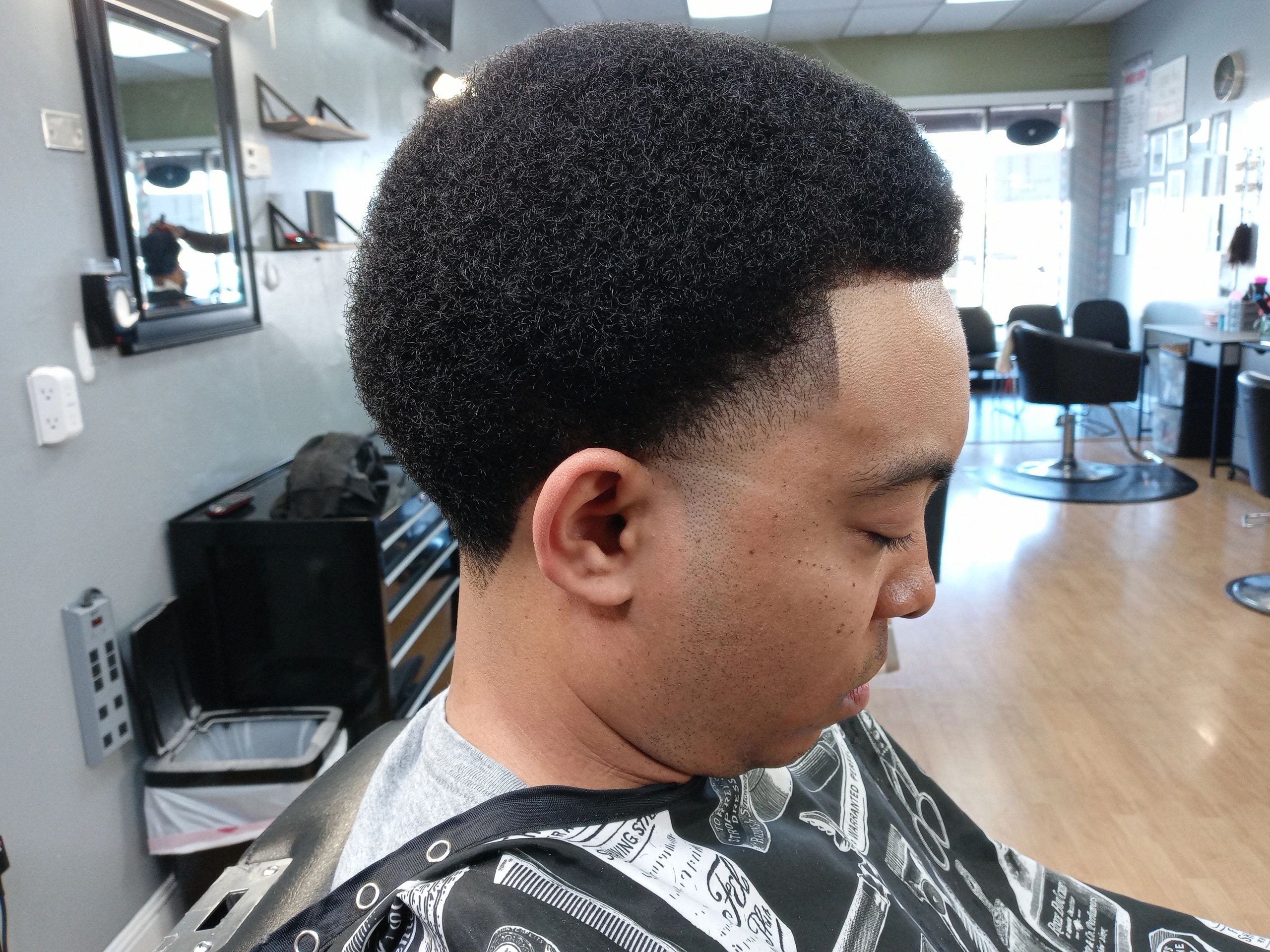 Side profile view of a man with a sharp fade haircut at JW Barbershop