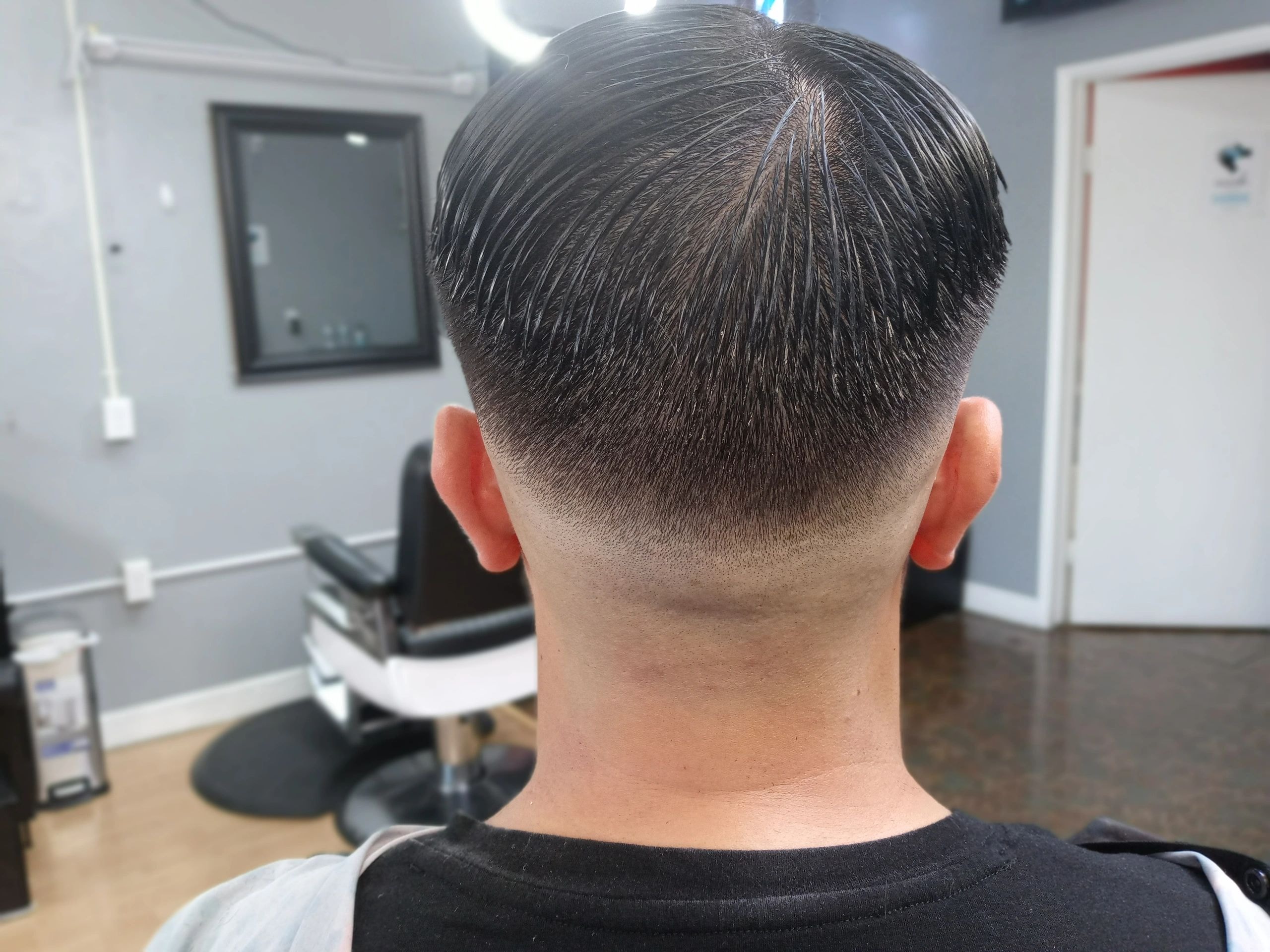 Rear view of a fresh barbershop haircut with clean lines and precise tapering