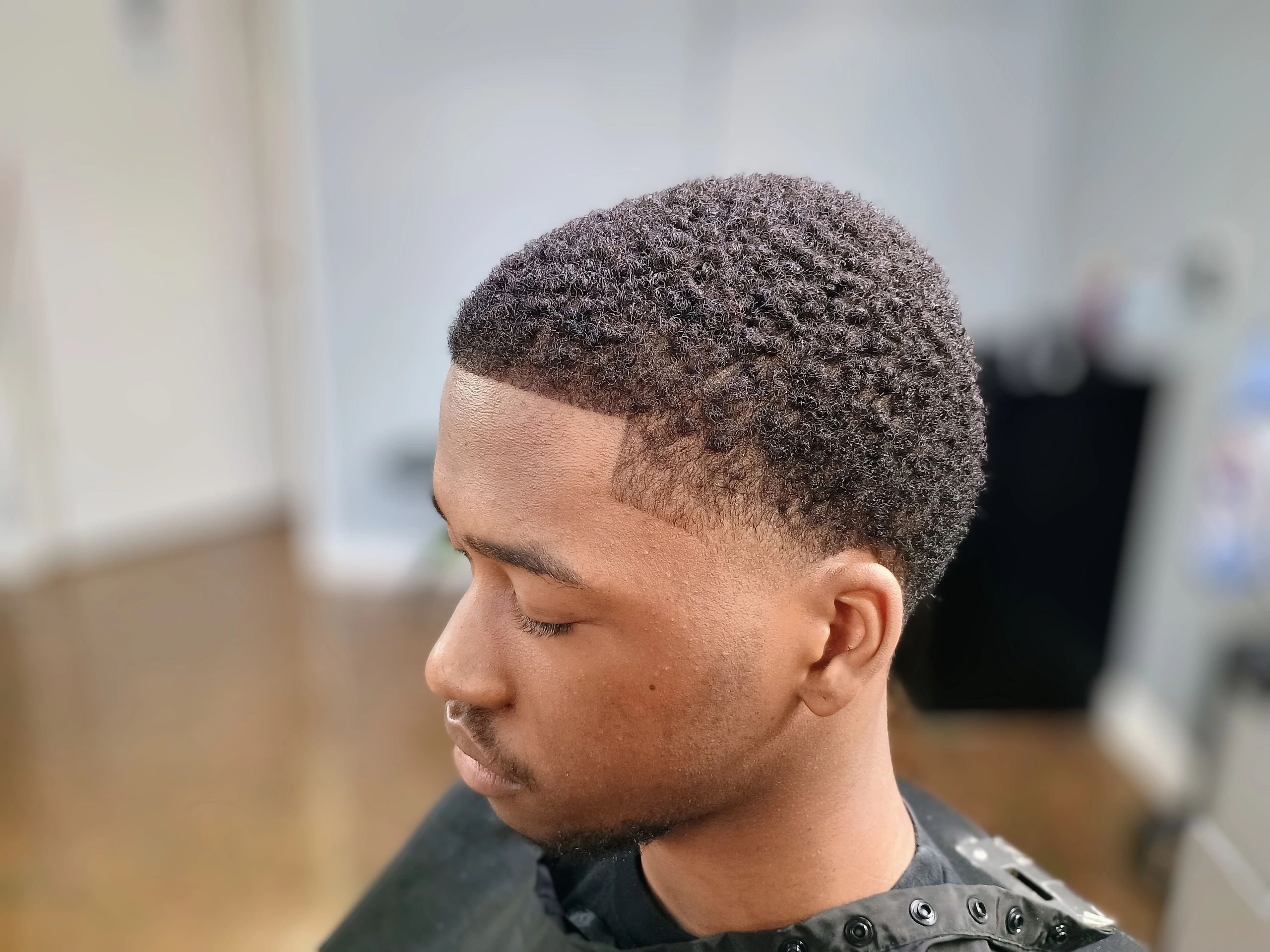 Man with a short textured crop haircut and well-groomed facial hair at JW Barbershop