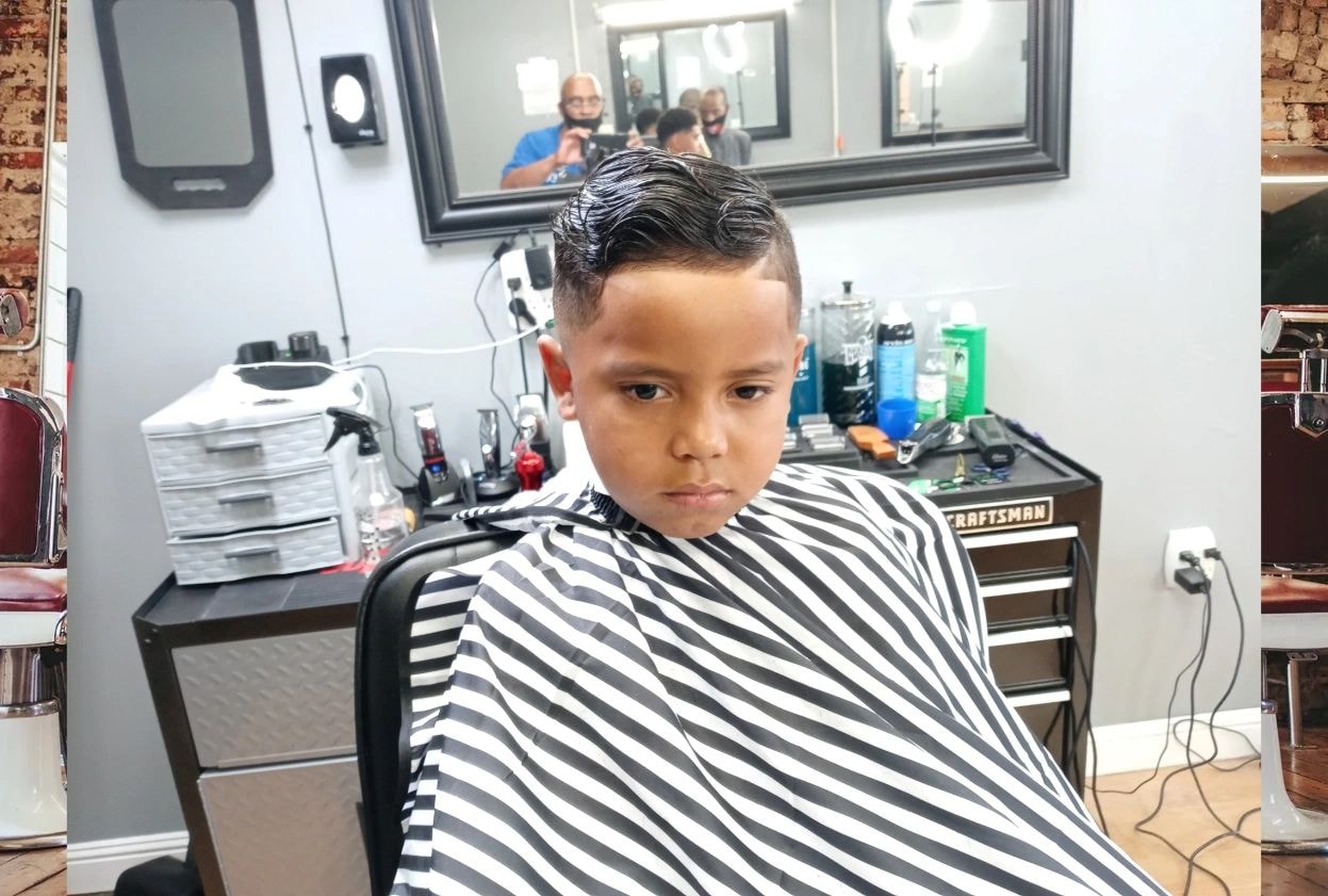 Young child receiving a professional fade haircut at JW Barbershop